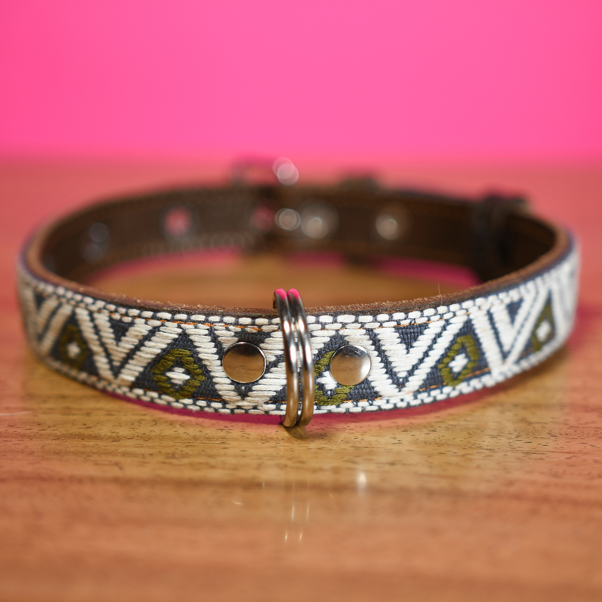 Full view of a Ceramic Cello leather dog collar laid out on a wooden table, emphasizing texture and color.