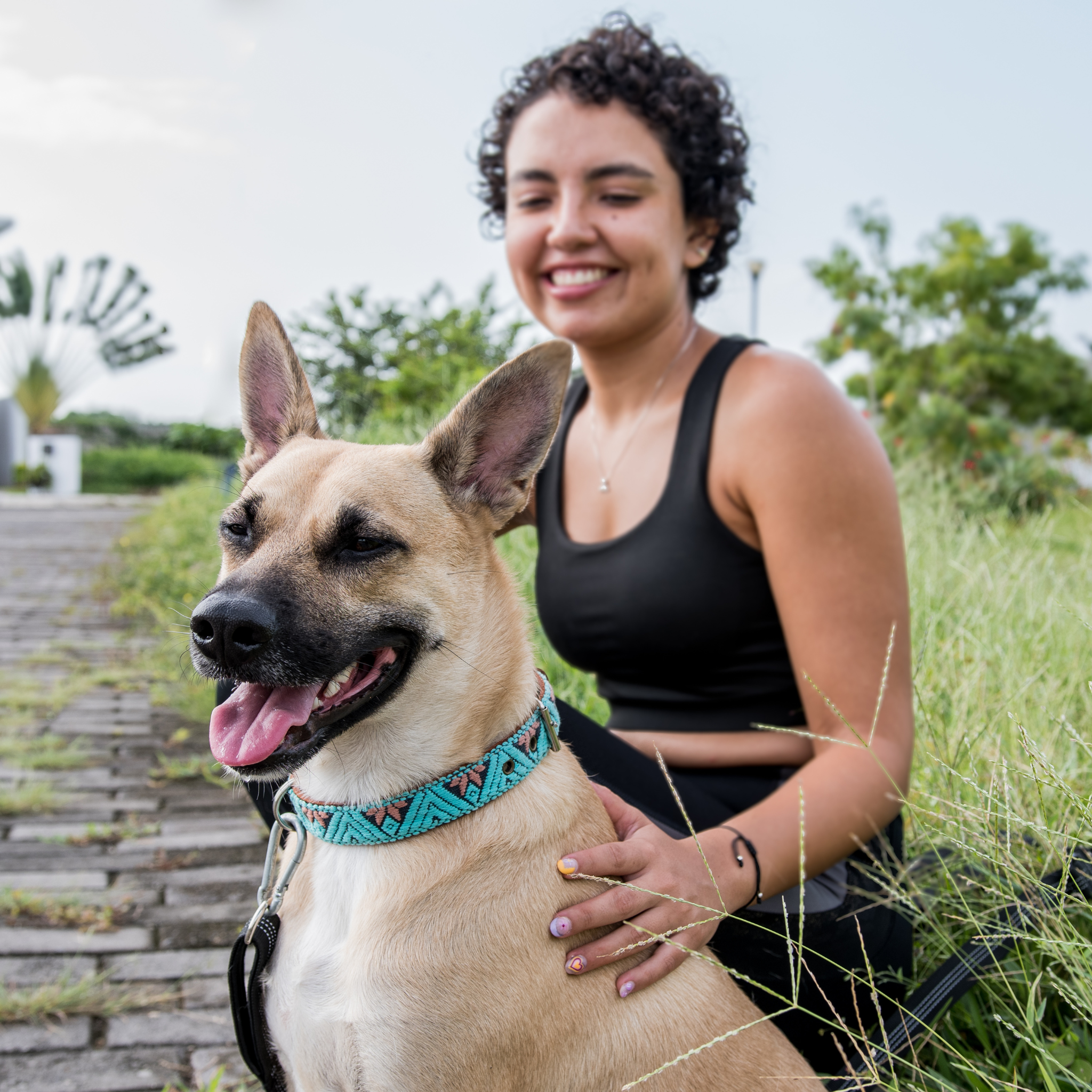A dog with its owner, both appearing happy and content, with the dog wearing a teal collar.